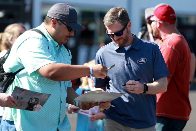 TALLADEGA, ALABAMA - OCTOBER 11: NBC broadcaster and former NASCAR driver Dale Earnhardt Jr. signs autographs in the garage area during practice for the NASCAR Gander Outdoor Truck Series Sugarlands Shine 250 at Talladega Superspeedway on October 11, 2019 in Talladega, Alabama. (Photo by Sean Gardner/Getty Images) | Getty Images