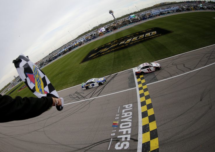 KANSAS CITY, KANSAS - OCTOBER 20: Denny Hamlin, driver of the #11 FedEx Office Toyota, takes the checkered flag ahead of Chase Elliott, driver of the #9 NAPA Auto Parts Chevrolet,  to win the Monster Energy NASCAR Cup Series Hollywood Casino 400 at Kansas Speedway on October 20, 2019 in Kansas City, Kansas. (Photo by Jonathan Ferrey/Getty Images) | Getty Images