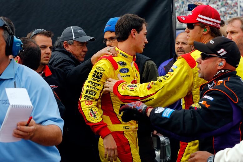 BRISTOL, TN - MARCH 17: Joey Logano, driver of the #22 Shell-Pennzoil Ford, gets held back by his crew member after an altercation with Denny Hamlin (not pictured), driver of the #11 FedEx Freight Toyota, after the NASCAR Sprint Cup Series Food City 500 at Bristol Motor Speedway on March 17, 2013 in Bristol, Tennessee. (Photo by Jared Wickerham/Getty Images) | Getty Images