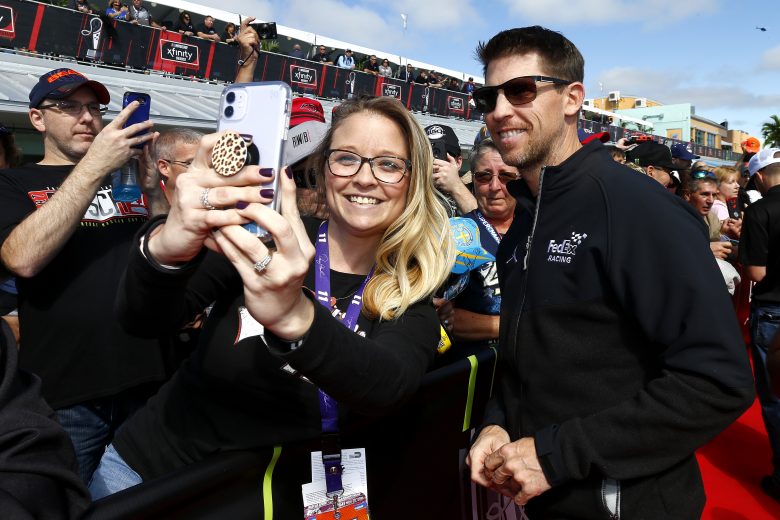 HOMESTEAD, FLORIDA - NOVEMBER 17:  Denny Hamlin, driver of the #11 FedEx Express Toyota, takes a photo with a fan during the driver's meeting prior to the Monster Energy NASCAR Cup Series Ford EcoBoost 400 at Homestead Speedway on November 17, 2019 in Homestead, Florida. (Photo by Jonathan Ferrey/Getty Images) | Getty Images