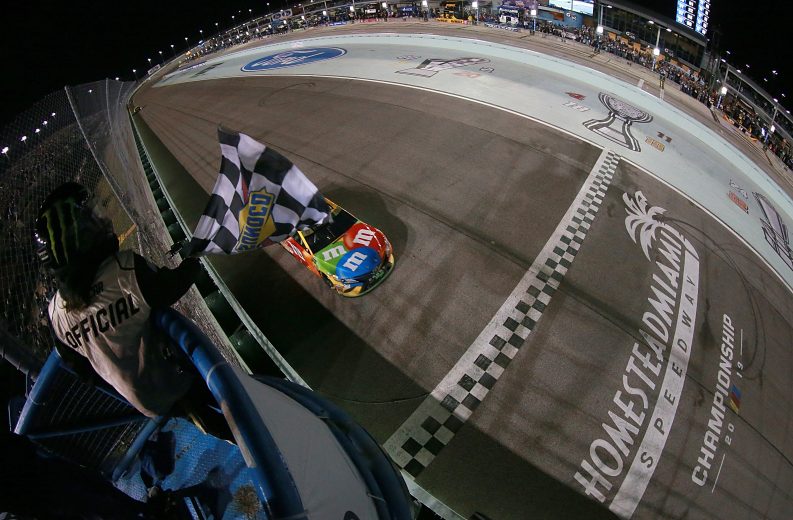 HOMESTEAD, FLORIDA - NOVEMBER 17: Kyle Busch, driver of the #18 M&M's Toyota, takes the checkered flag to win the Monster Energy NASCAR Cup Series Cahmpionship and  the Monster Energy NASCAR Cup Series Ford EcoBoost 400 at Homestead Speedway on November 17, 2019 in Homestead, Florida. (Photo by Sean Gardner/Getty Images) | Getty Images