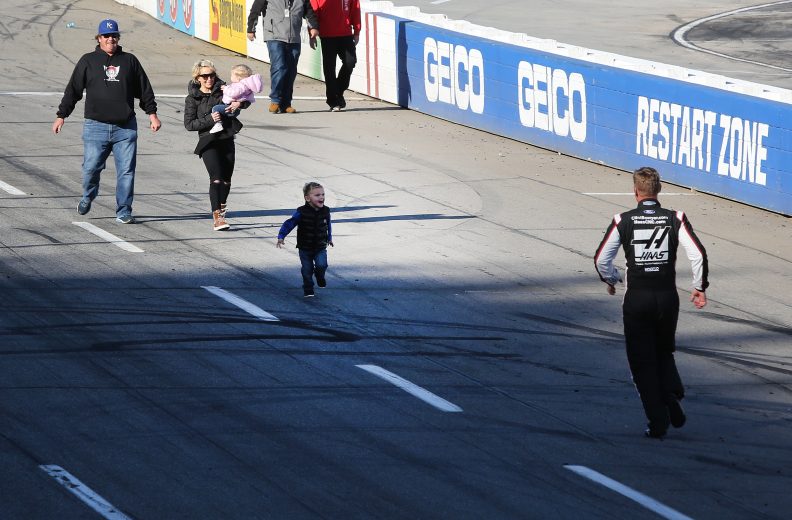MARTINSVILLE, VA - MARCH 26: Clint Bowyer, driver of the #14 Haas Automation Demo Day Ford, runs to greet his son, Cash, as his wife, Lorra, and their daughter Presley look on after winning the weather delayed Monster Energy NASCAR Cup Series STP 500 at Martinsville Speedway on March 26, 2018 in Martinsville, Virginia. (Photo by Jerry Markland/Getty Images) | Getty Images
