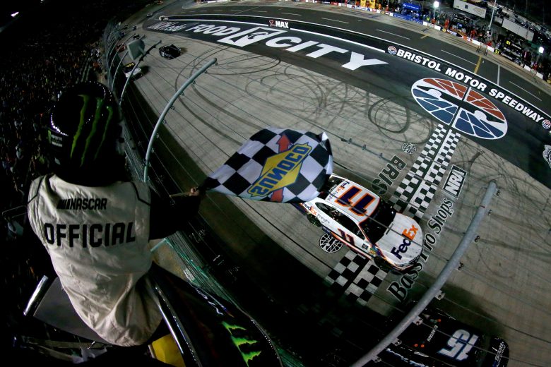 BRISTOL, TENNESSEE - AUGUST 17: Denny Hamlin, driver of the #11 FedEx Freight Toyota, takes the checkered flag to win the Monster Energy NASCAR Cup Series Bass Pro Shops NRA Night Race at Bristol Motor Speedway on August 17, 2019 in Bristol, Tennessee. (Photo by Sean Gardner/Getty Images) | Getty Images
