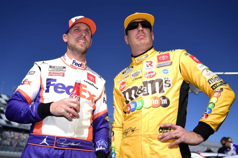 DAYTONA BEACH, FLORIDA - FEBRUARY 09: Kyle Busch, driver of the #18 M&M's Toyota, and Denny Hamlin, driver of the #11 FedEx Express Toyota, stand on the grid during qualifying for the NASCAR Cup Series 62nd Annual Daytona 500 at Daytona International Speedway on February 09, 2020 in Daytona Beach, Florida. (Photo by Jared C. Tilton/Getty Images) | Getty Images