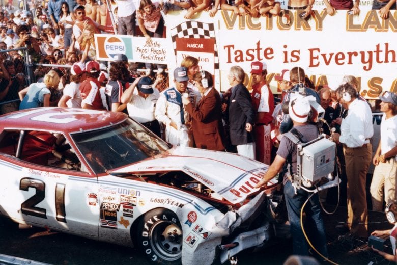 DAYTONA BEACH, FL - FEBRUARY 15, 1976: David Pearson explains in victory lane how he managed to get his thoroughly crashed Mercury across the finish line to win the 1976 Daytona 500. Pearson crashed with Richard Petty, but was able to drive across the line on the engine?s starter motor. (Photo by ISC Archives/CQ-Roll Call Group via Getty Images)