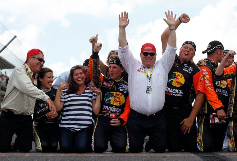 INDIANAPOLIS - JULY 25:  (C) Jamie McMurray, driver of the #1 Bass Pro Shops/Tracker Boats Chevrolet, celebrates by kissing the bricks with wife (3rd L) Christy McMurray, co-owner (4th L) Felix Sabates, (2nd R) Chip Ganassi and crew chief Kevin Manion after winning the NASCAR Sprint Cup Series Brickyard 400 at Indianapolis Motor Speedway on July 25, 2010 in Indianapolis, Indiana.  (Photo by Jason Smith/Getty Images) | Getty Images
