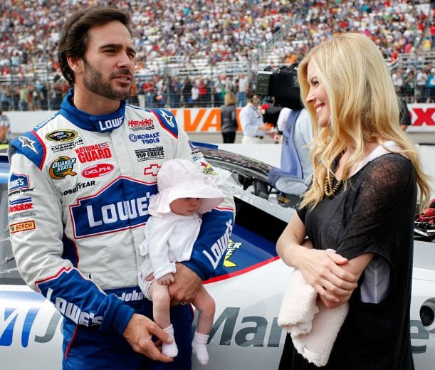 LOUDON, NH - SEPTEMBER 19: Jimmie Johnson, driver of the #48 Lowe's / Johns Manville Chevrolet, holds his baby daughter Genevieve Marie as his wife Chandra looks on from the grid prior to the start of the NASCAR Sprint Cup Series Sylvania 300 at New Hampshire Motor Speedway on September 19, 2010 in Loudon, New Hampshire. (Photo by Jeff Zelevansky/Getty Images) | Getty Images