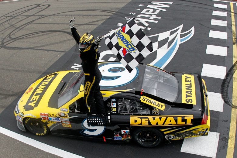 WATKINS GLEN, NY - AUGUST 15: Marcos Ambrose, driver of the #9 Stanley Ford, celebrates with the checkered flag after winning the NASCAR Sprint Cup Series Heluva Good! Sour Cream Dips at the Glen at Watkins Glen International on August 15, 2011 in Watkins Glen, New York. (Photo by Chris Graythen/Getty Images) | Getty Images