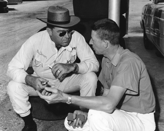 UNKNOWN — 1966: Driver Curtis Turner sits on a tire as he talks with his car owner, Glen Wood, before a NASCAR Cup race. Turner drove his first six races of the NASCAR Cup season for the Wood Brothers team before Ford pulled out of Cup racing, leaving the Woods’ team on the sidelines for the better part of the year. (Photo by ISC Images & Archives via Getty Images)