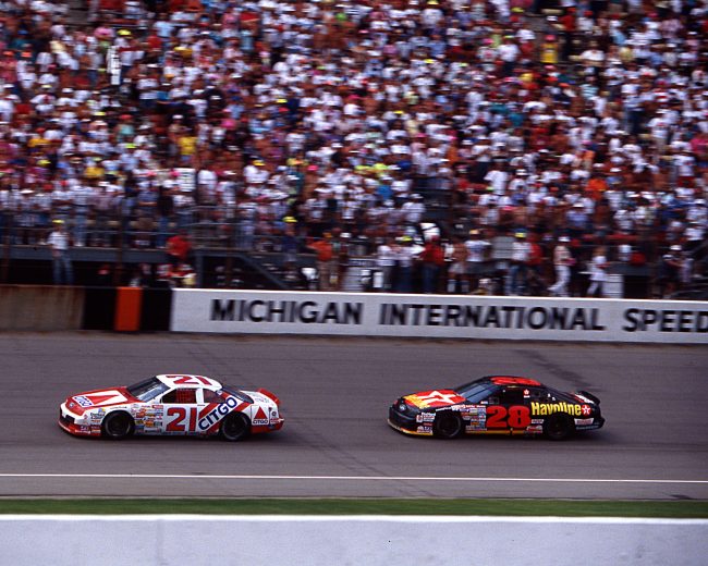 BROOKLYN, MI — August 18, 1991: Dale Jarrett (No. 21) in the Wood Brothers Citgo Ford leads Davey Allison (No. 28) to the checkered flag to win his first NASCAR Cup race, the Champion Spark Plug 400 at Michigan International Speedway. (Photo by ISC Images & Archives via Getty Images)