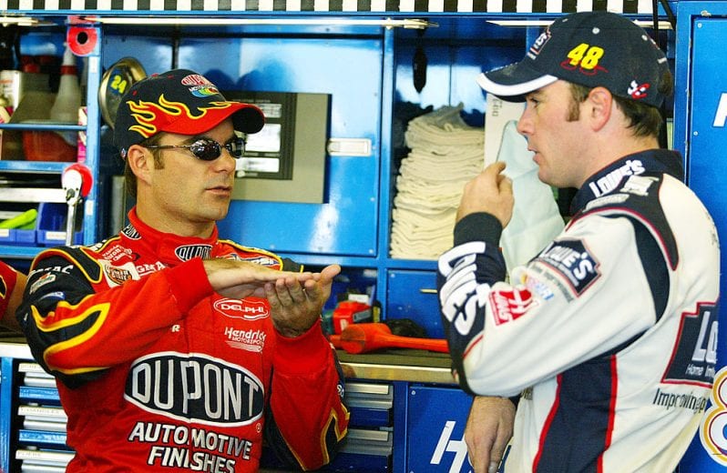 LOUDON, NH - SEPTEMBER 13: Jeff Gordon talks with teammate Jimmie Johnson during practice for the New Hampshire 300, part of the NASCAR Winston Cup Series, at the New Hampshire International Speedway on September 13, 2002 in Loudon, New Hampshire. (Photo by Donald Miralle/Getty Images) | Getty Images