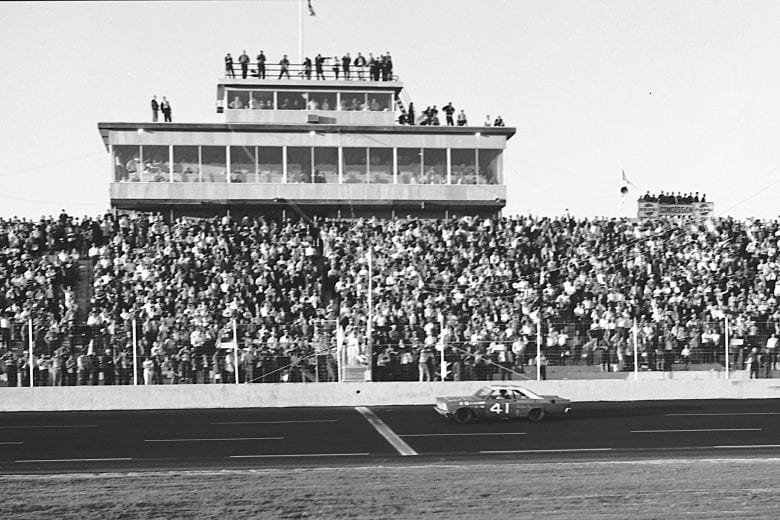 ROCKINGHAM, NC - OCTOBER 31. 1965: Curtis Turner takes the checkered flag to win the American 500 NASCAR Cup race, the first event to be held at the new North Carolina Motor Speedway. Driving a Ford for the Wood Brothers, Turner dominated the event, leading 239 laps and winning by 11 seconds over second-place Cale Yarborough. (Photo by ISC Images & Archives via Getty Images)