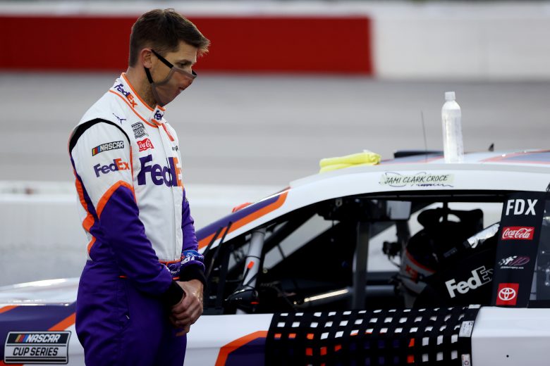 DARLINGTON, SOUTH CAROLINA - MAY 20: Denny Hamlin, driver of the #11 FedEx Delivering Strength Toyota, stands on the grid during the national anthem prior to the NASCAR Cup Series Toyota 500 at Darlington Raceway on May 20, 2020 in Darlington, South Carolina. (Photo by Chris Graythen/Getty Images) | Getty Images