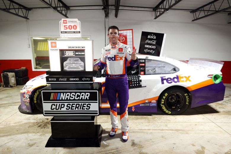 DARLINGTON, SOUTH CAROLINA - MAY 20: Denny Hamlin, driver of the #11 FedEx Delivering Strength Toyota, celebrates in Victory Lane after winning the rain-shortened NASCAR Cup Series Toyota 500 at Darlington Raceway on May 20, 2020 in Darlington, South Carolina. (Photo by Chris Graythen/Getty Images) | Getty Images