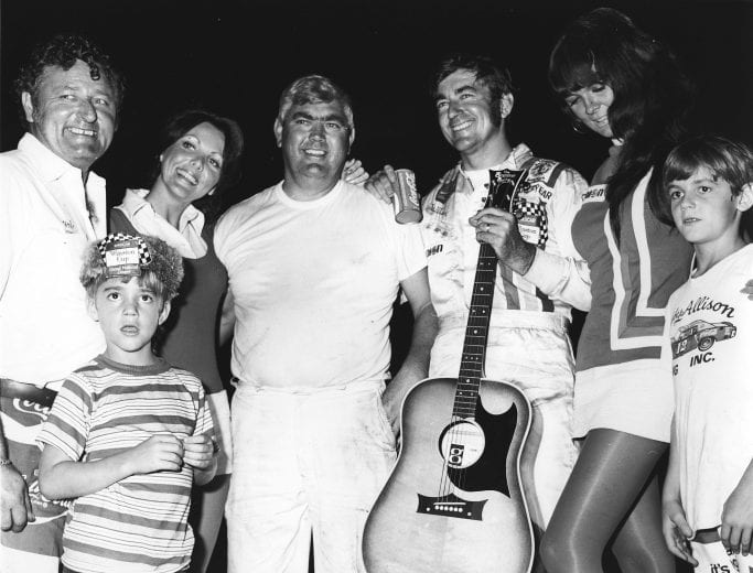 NASHVILLE, TN — August 27, 1972: Bobby Allison holds a victory guitar as he stands next to Junior Johnson after winning the Nashville 420 NASCAR Cup race at Nashville Fairgrounds Speedway. Mechanic Herb Nab (L) joins the celebration. (Photo by ISC Images & Archives via Getty Images)