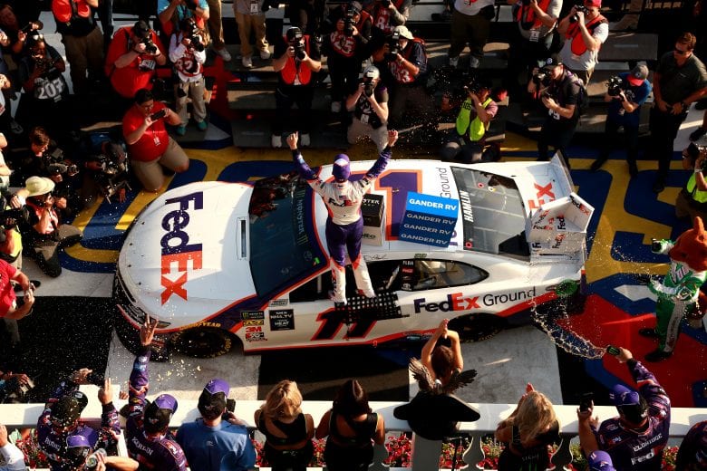 LONG POND, PENNSYLVANIA - JULY 28: Denny Hamlin, driver of the #11 FedEx Ground Toyota, celebrates in Victory Lane after winning the Monster Energy NASCAR Cup Series Gander RV 400 at Pocono Raceway on July 28, 2019 in Long Pond, Pennsylvania. (Photo by Sean Gardner/Getty Images) | Getty Images