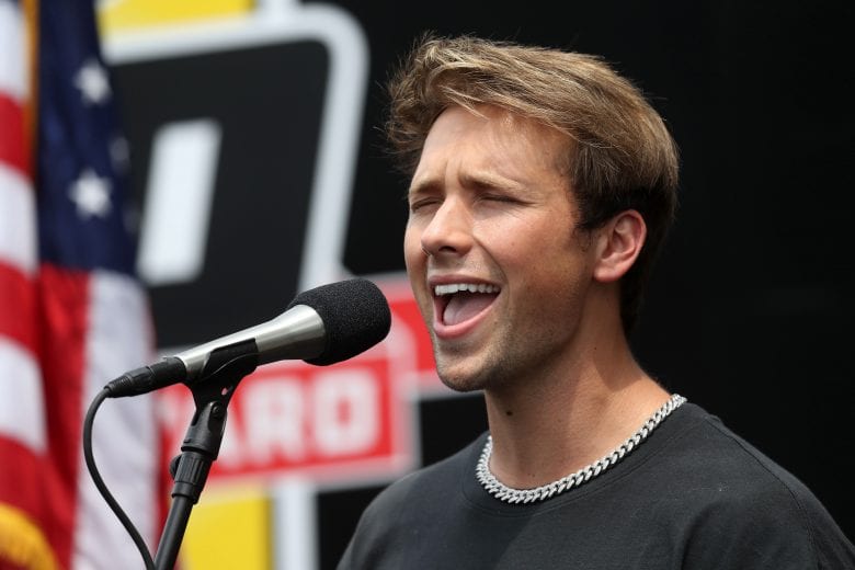 INDIANAPOLIS, INDIANA - JULY 04:  Noah Schnacky sings the National Anthem prior to the NASCAR Xfinity Series Pennzoil 150 at the Brickyard at Indianapolis Motor Speedway on July 04, 2020 in Indianapolis, Indiana. (Photo by Chris Graythen/Getty Images) | Getty Images