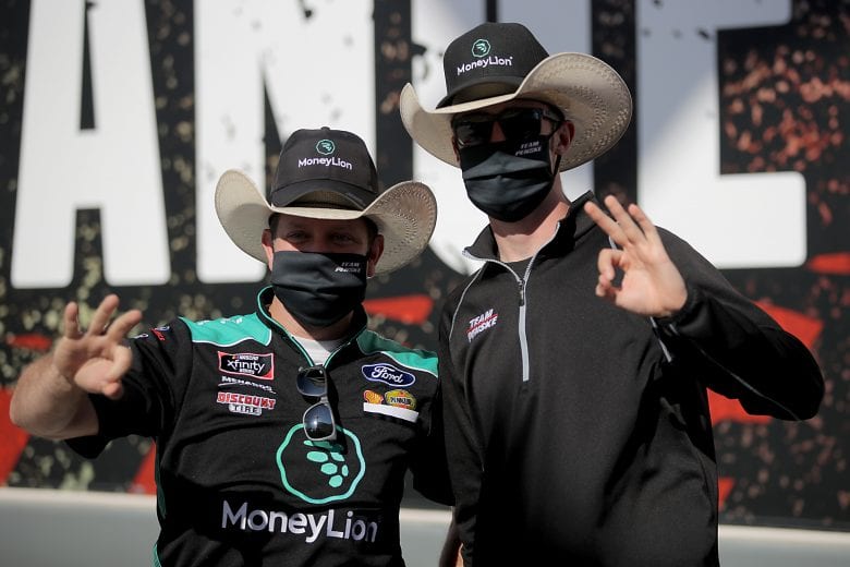FORT WORTH, TEXAS - JULY 18: Austin Cindric, driver of the #22 MoneyLion Ford, and his crew chief Brian Wilson pose for a photo opportunity in Victory Lane after being awarded the victory when Kyle Busch, driver of the #54 Twix Cookies & Creme Toyota, failed post-race inspection following the NASCAR Xfinity Series Bariatric Solutions 300 at Texas Motor Speedway on July 18, 2020 in Fort Worth, Texas. (Photo by Chris Graythen/Getty Images) | Getty Images