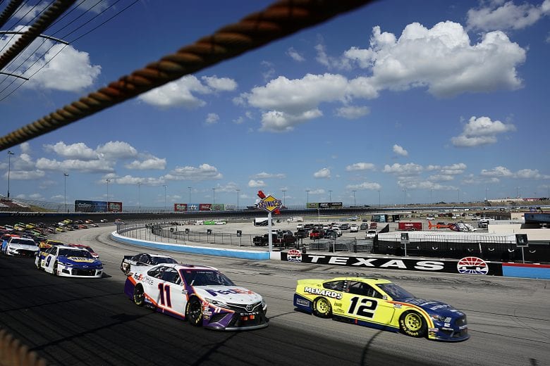 FORT WORTH, TEXAS - JULY 19: Denny Hamlin, driver of the #11 FedEx Office Toyota, and Ryan Blaney, driver of the #12 Menards/Maytag Ford, lead the field during the NASCAR Cup Series O'Reilly Auto Parts 500 at Texas Motor Speedway on July 19, 2020 in Fort Worth, Texas. (Photo by Cooper Neill/Getty Images)