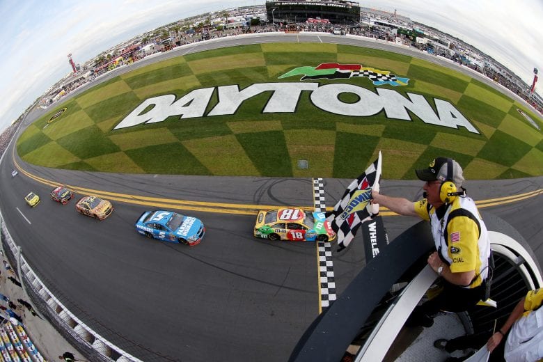 DAYTONA BEACH, FL - FEBRUARY 21:  Kyle Busch, driver of the #18 M&M's Toyota, crosses the finish line to take the checkered flag to win the NASCAR Sprint Cup Series Budweiser Duel 2 at Daytona International Speedway on February 21, 2013 in Daytona Beach, Florida.  (Photo by Tom Pennington/NASCAR via Getty Images)