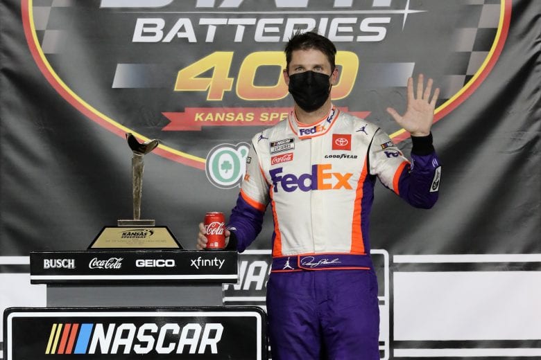 KANSAS CITY, KANSAS - JULY 23: Denny Hamlin, driver of the #11 FedEx Office Toyota, celebrates in Victory Lane after winning the NASCAR Cup Series Super Start Batteries 400 Presented by O'Reilly Auto Parts at Kansas Speedway on July 23, 2020 in Kansas City, Kansas. (Photo by Jamie Squire/Getty Images) | Getty Images