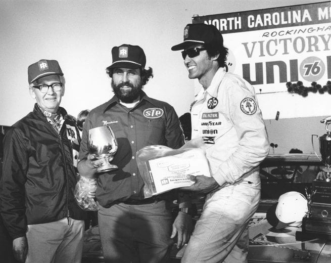 ROCKINGHAM, NC: Maurice Petty (C), Richard's brother and engine builder, accepts a mechanic's award from Ingersoll Rand. Richard (R) looks on. (Photo by ISC Archives/CQ-Roll Call Group via Getty Images)