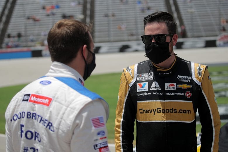 FORT WORTH, TEXAS - JULY 19: Alex Bowman, driver of the #88 ChevyGoods.com/Adam's Polishes Chevrolet, speaks with Matt DiBenedetto, driver of the #21 Motorcraft/Quick Lane Ford, on the grid prior to the NASCAR Cup Series O'Reilly Auto Parts 500 at Texas Motor Speedway on July 19, 2020 in Fort Worth, Texas. (Photo by Chris Graythen/Getty Images) | Getty Images