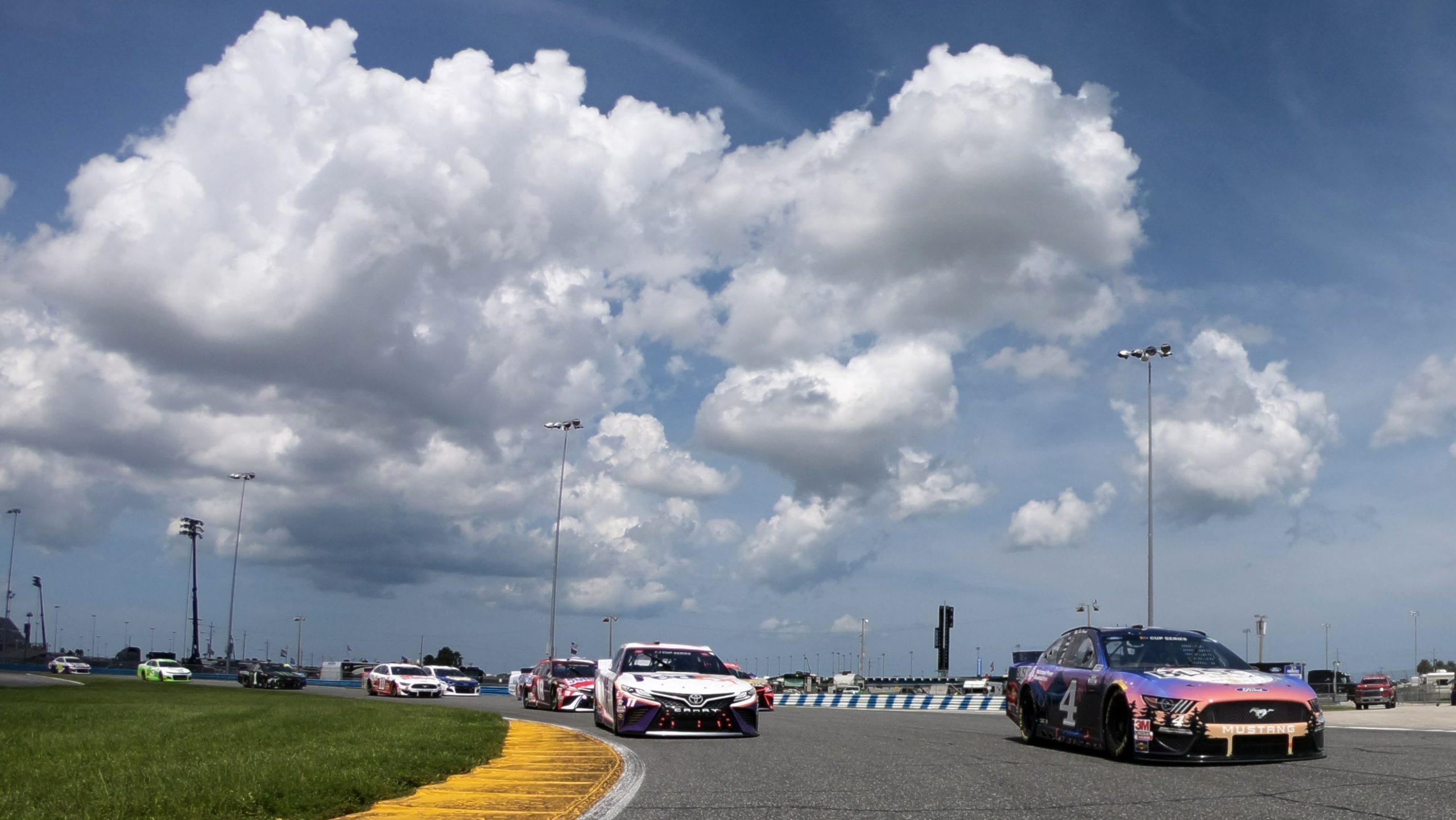 DAYTONA BEACH, FLORIDA - AUGUST 16:  Kevin Harvick, driver of the #4 Busch Beer National Forest Foundation Ford, and Denny Hamlin, driver of the #11 FedEx Freight Toyota, lead the field on a pace lap prior to ASCAR Cup Series Go Bowling 235 at Daytona International Speedway on August 16, 2020 in Daytona Beach, Florida. (Photo by Chris Graythen/Getty Images) | Getty Images