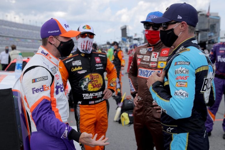 DAYTONA BEACH, FLORIDA - AUGUST 16: (L-R) Denny Hamlin, driver of the #11 FedEx Freight Toyota, Martin Truex Jr., driver of the #19 Bass Pro Shops Toyota, Kyle Busch, driver of the #18 Snickers Toyota, and Kevin Harvick, driver of the #4 Busch Beer National Forest Foundation Ford, talk on the grid prior to the NASCAR Cup Series Go Bowling 235 at Daytona International Speedway on August 16, 2020 in Daytona Beach, Florida. (Photo by Chris Graythen/Getty Images) | Getty Images