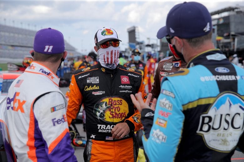 DAYTONA BEACH, FLORIDA - AUGUST 16: Martin Truex Jr., driver of the #19 Bass Pro Shops Toyota, speaks to Denny Hamlin, driver of the #11 FedEx Freight Toyota, and Kevin Harvick, driver of the #4 Busch Beer National Forest Foundation Ford, prior to the NASCAR Cup Series Go Bowling 235 at Daytona International Speedway on August 16, 2020 in Daytona Beach, Florida. (Photo by Chris Graythen/Getty Images) | Getty Images