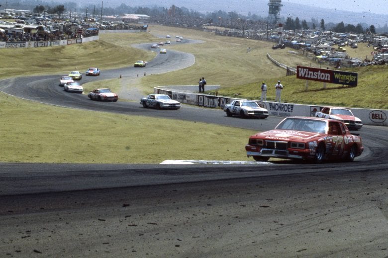RIVERSIDE, CA - 1984:  Tim Richmond leads a group of cars through a turn during a NASCAR Cup race at Riverside International Raceway. (Photo by ISC Images & Archives via Getty Images)