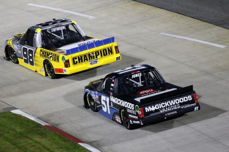 MARTINSVILLE, VIRGINIA - OCTOBER 30: Grant Enfinger, driver of the #98 Champion/Curb Records Ford, and Brandon Jones, driver of the #51 Magick Woods Vanities Toyota, race during the NASCAR Gander RV & Outdoors Truck Series NASCAR Hall of Fame 200 at Martinsville Speedway on October 30, 2020 in Martinsville, Virginia. (Photo by Brian Lawdermilk/Getty Images) | Getty Images
