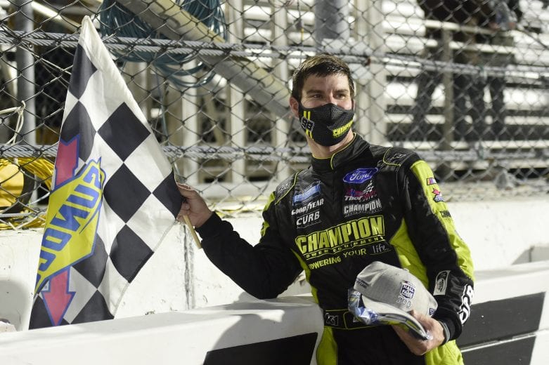 MARTINSVILLE, VIRGINIA - OCTOBER 30: Grant Enfinger, driver of the #98 Champion/Curb Records Ford, celebrates with the checkered flag after winning the NASCAR Gander RV & Outdoors Truck Series NASCAR Hall of Fame 200 at Martinsville Speedway on October 30, 2020 in Martinsville, Virginia. (Photo by Jared C. Tilton/Getty Images) | Getty Images