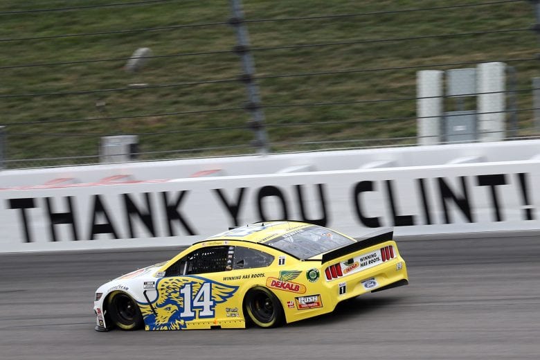 KANSAS CITY, KANSAS - OCTOBER 18: Clint Bowyer, driver of the #14 DEKALB Ford, drives by a sign that reads,