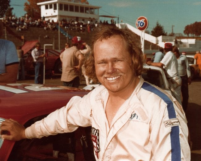 UNKNOWN — Early-1980s: The term “rubbin’ is racin’” can certainly apply to Richmond, VA, driver “Terrible” Tommy Ellis, who earned his nickname from the fact he wasn’t afraid to use his car’s bumper to help him win a race. Here, Ellis gives that little “grin” he probably gave other drivers many times as he passed them on his way to victory. (Photo by ISC Images & Archives via Getty Images)