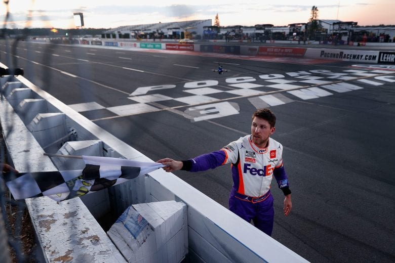 LONG POND, PENNSYLVANIA - JUNE 28: Denny Hamlin, driver of the #11 FedEx Ground Toyota, takes the checkered flag after winning during the NASCAR Cup Series Pocono 350 at Pocono Raceway on June 28, 2020 in Long Pond, Pennsylvania. (Photo by Patrick Smith/Getty Images) | Getty Images