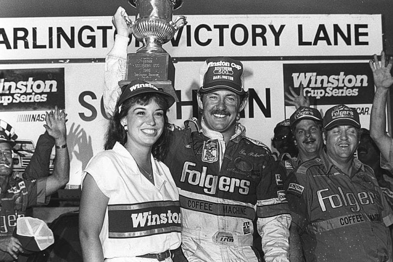 DARLINGTON, SC — August 31, 1986: Tim Richmond celebrates with Miss Winston and his Rick Hendrick Folgers Coffee crew in victory lane at Darlington Raceway after winning the Southern 500 NASCAR Cup race.  (Photo by ISC Images & Archives via Getty Images)