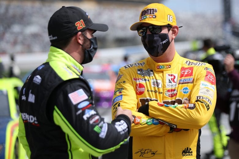 HAMPTON, GEORGIA - MARCH 21: Kyle Busch, driver of the #18 M&M's Messages Toyota, and Matt DiBenedetto, driver of the #21 Menards/Maytag Ford, talk on the grid prior to the NASCAR Cup Series Folds of Honor QuikTrip 500 at Atlanta Motor Speedway on March 21, 2021 in Hampton, Georgia. (Photo by Sean Gardner/Getty Images) | Getty Images