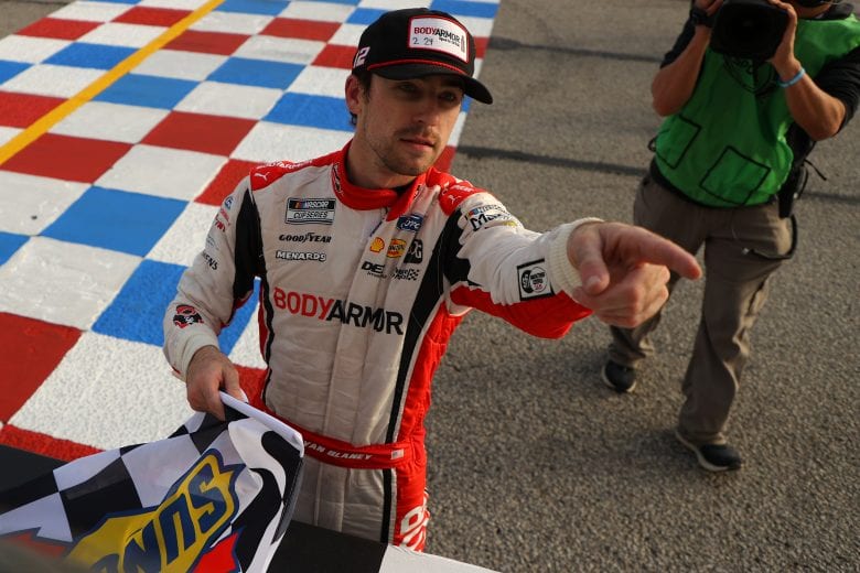 HAMPTON, GEORGIA - MARCH 21: Ryan Blaney, driver of the #12 BodyArmor Ford, points to a young NASCAR fan to receive the Sunoco flag after winning the NASCAR Cup Series Folds of Honor QuikTrip 500 at Atlanta Motor Speedway on March 21, 2021 in Hampton, Georgia. (Photo by Kevin C. Cox/Getty Images) | Getty Images
