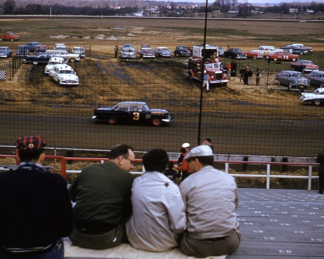 UNKNOWN — 1957: Fans get a view of Paul Goldsmith’s No. 3 Ford during a NASCAR Cup race on a dirt track. Driving for Henry “Smokey” Yunick, Goldsmith took three of his four wins on the Cup circuit during the year in Yunick’s car. (Photo by ISC Images & Archives via Getty Images)