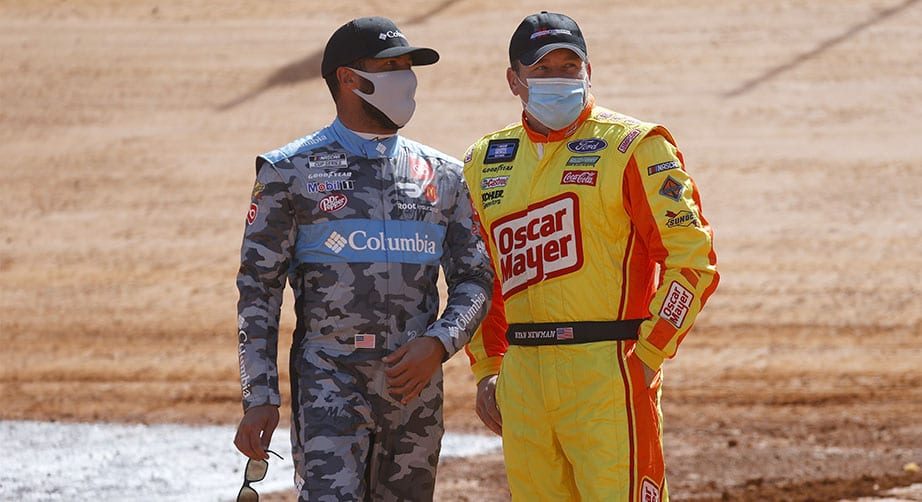 BRISTOL, TENNESSEE - MARCH 26: Ryan Newman, driver of the #39 Diversified Custom Concepts Ford, and Denny Hamlin, driver of the #11 FedEx Freight Toyota, talk on the track during practice for the NASCAR Camping World Truck Series Pinty's Truck Race on Dirt at Bristol Motor Speedway on March 26, 2021 in Bristol, Tennessee. (Photo by Chris Graythen/Getty Images) | Getty Images
