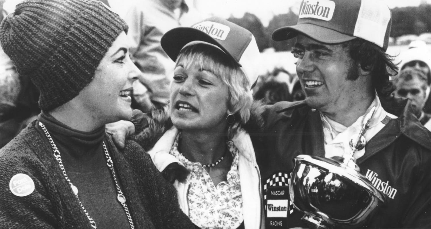 MARTINSVILLE, VA - 1976: Actress Elizabeth Taylor joins Geoff Bodine in victory lane after Bodine won the NASCAR Modified portion of the Cardinal 500 at Martinsville Speedway. (Photo by ISC Images & Archives via Getty Images)