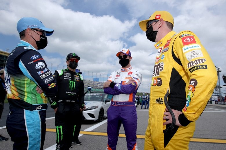 KANSAS CITY, KANSAS - MAY 02: Kevin Harvick, driver of the #4 Busch Light For The Farmers Ford, Kurt Busch, driver of the #1 Monster Energy Chevrolet, Denny Hamlin, driver of the #11 FedEx Freight Toyota, Kyle Busch, driver of the #18 M&M's Mix Toyota, talk on the grid prior to the NASCAR Cup Series Buschy McBusch Race 400 at Kansas Speedway on May 02, 2021 in Kansas City, Kansas. (Photo by Sean Gardner/Getty Images) | Getty Images