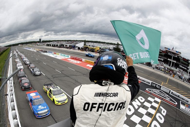 LONG POND, PENNSYLVANIA - JUNE 26: A NASCAR Official waves the green flag as Matt Crafton, driver of the #88 Ideal Door/Menards Toyota, and Stewart Friesen, driver of the #52 Halmar International Toyota, start the NASCAR Cup Series Pocono Organics CBD 325 at Pocono Raceway on June 26, 2021 in Long Pond, Pennsylvania. (Photo by Tim Nwachukwu/Getty Images) | Getty Images
