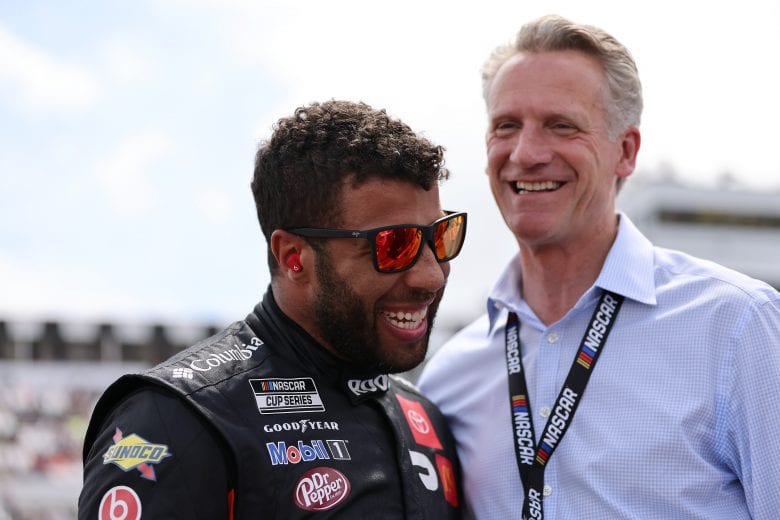 LONG POND, PENNSYLVANIA - JUNE 26: Bubba Wallace, driver of the #23 Root Insurance Toyota, and NASCAR President Steve Phelps share a laugh on the grid prior to the NASCAR Cup Series Pocono Organics CBD 325 at Pocono Raceway on June 26, 2021 in Long Pond, Pennsylvania. (Photo by James Gilbert/Getty Images) | Getty Images