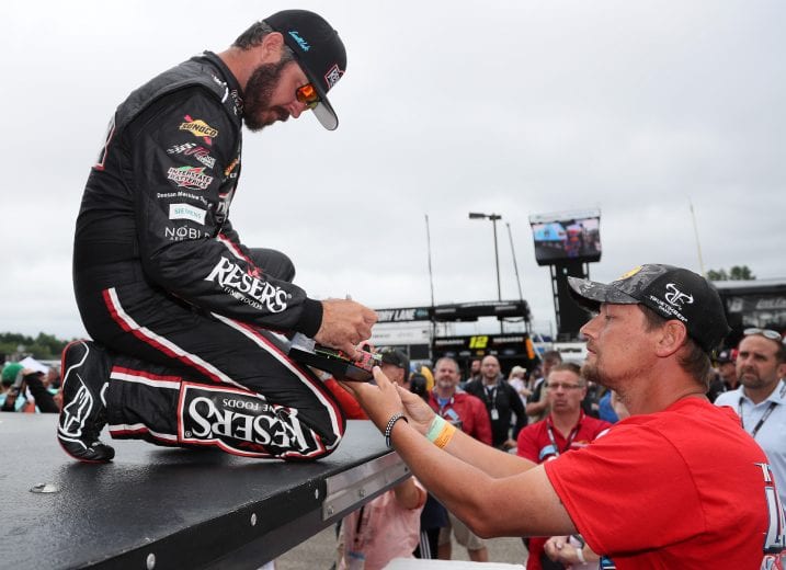 LOUDON, NEW HAMPSHIRE - JULY 18: Martin Truex Jr., driver of the #19 Resers Fine Foods #LetsPicnic Toyota, sings autographs for fans during pre-race ceremonies prior to the NASCAR Cup Series Foxwoods Resort Casino 301 at New Hampshire Motor Speedway on July 18, 2021 in Loudon, New Hampshire. (Photo by James Gilbert/Getty Images) | Getty Images
