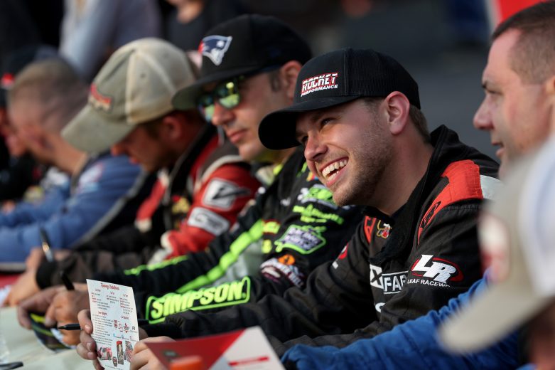 Tommy Catalano, driver of the #54 FX Capera Chevrolet, smiles while signing autographs prior to the Nu Way Auto Parts 150 for the NASCAR Whelen Modified Tour at New York International Raceway Park in Lancaster, New York on July 31, 2021. (Bryan Bennett/NASCAR)