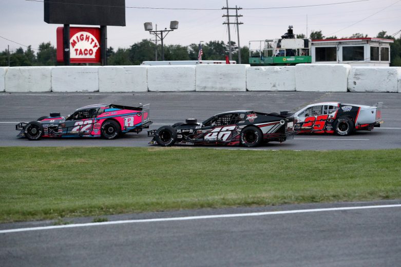 Kyle Bonsignore, driver of the #22 Chateau Performance, Magnus, Tilton, and Wilwo Chevrolet, Craig Lutz, driver of the #46 Riverhead Building Supply Chevrolet, and Mike Leaty, driver of the #25 Northeast Industrials Technology, race during the Nu Way Auto Parts 150 for the NASCAR Whelen Modified Tour at New York International Raceway Park in Lancaster, New York on July 31, 2021. (Bryan Bennett/NASCAR)