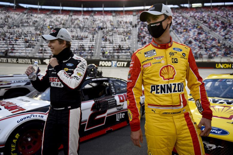 BRISTOL, TENNESSEE - SEPTEMBER 19: Brad Keselowski, driver of the #2 Discount Tire Ford, and Joey Logano, driver of the #22 Shell Pennzoil Ford, laugh on the grid prior to the NASCAR Cup Series Bass Pro Shops Night Race at Bristol Motor Speedway on September 19, 2020 in Bristol, Tennessee. (Photo by Jared C. Tilton/Getty Images) | Getty Images