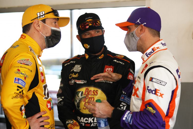 DAYTONA BEACH, FLORIDA - FEBRUARY 10: Kyle Busch, driver of the #18 M&M's Toyota, Martin Truex Jr., driver of the #19 Bass Pro Shops Toyota, and Denny Hamlin, driver of the #11 FedEx Toyota, talk in the garage area during practice for the NASCAR Cup Series 63rd Annual Daytona 500 at Daytona International Speedway on February 10, 2021 in Daytona Beach, Florida. (Photo by Chris Graythen/Getty Images) | Getty Images